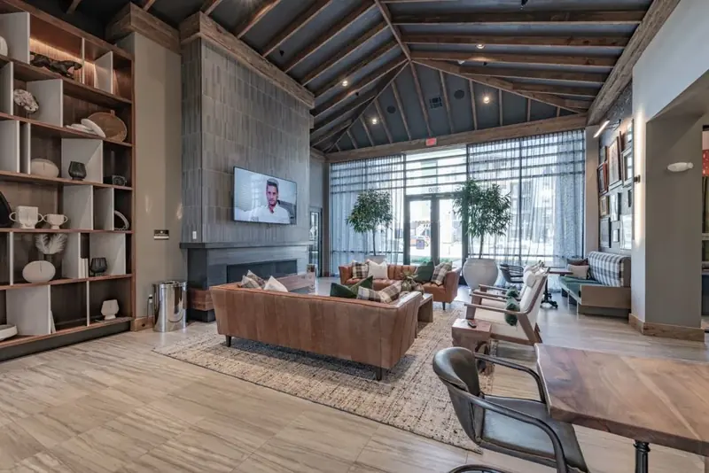 Clubhouse social lounge with vaulted wood ceilings, fireplace and leather sofas